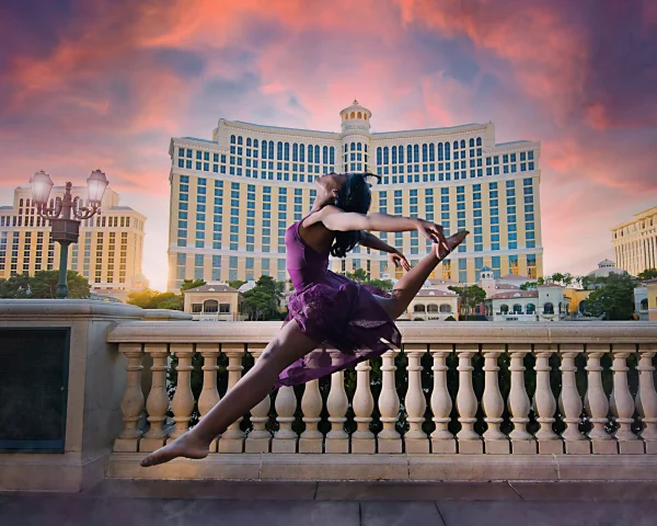 Las Vegas Strip senior portraits senior dancer performing a leap with Bellagio in the background at sunset