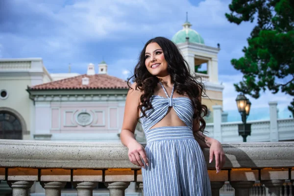 Las Vegas Strip senior portraits senior girl in a striped jumpsuit posing in front of Bellagio architecture
