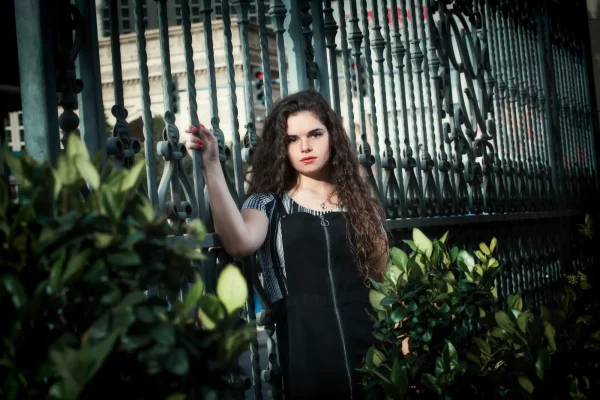 Las Vegas Strip senior portraits senior girl in a black dress posing near an ornate fence on Las Vegas Boulevard