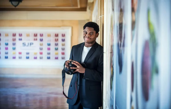 Las Vegas Strip senior portraits senior guy in a suit holding a camera at Bellagio