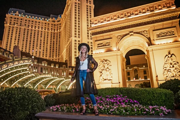 Las Vegas Strip senior portraits senior girl in a hat and long jacket posing at Paris Las Vegas at night