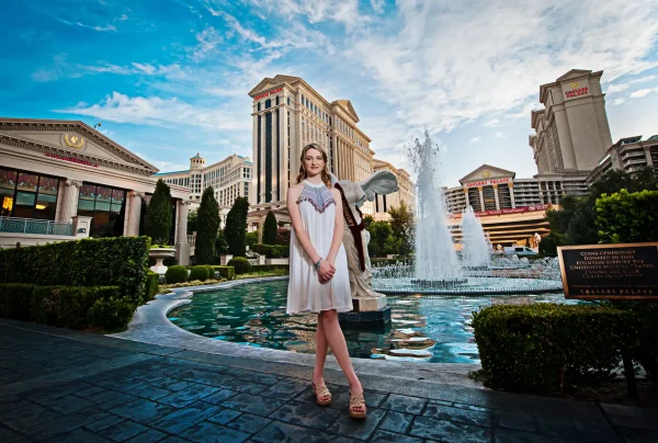 Las Vegas Strip senior portraits senior girl in a white dress posing in front of a Caesars Palace fountain
